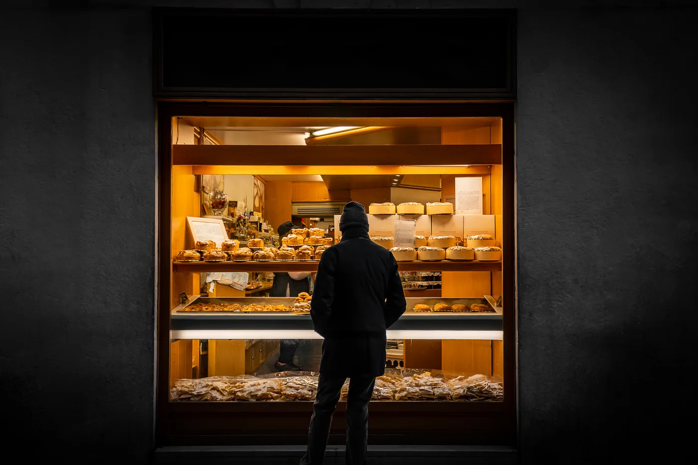 Passant vor einem beleuchteten Schaufenster am Abend